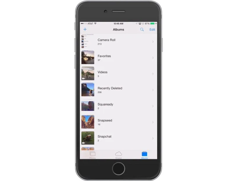 A black iPhone showing photo albums in the Photos app