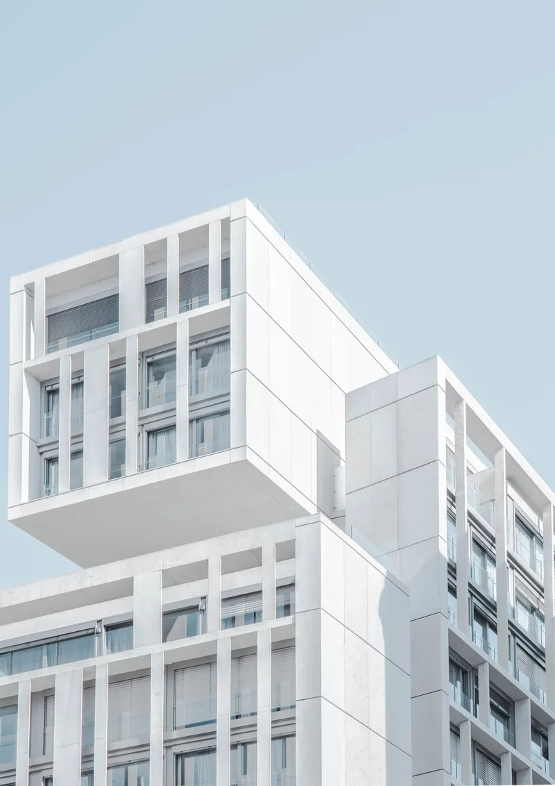 a modern, modular white building with crisp architecture against a light blue sky